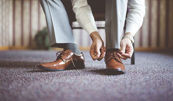 closeup shot of a male tying his shoes and getting ready for a business meeting